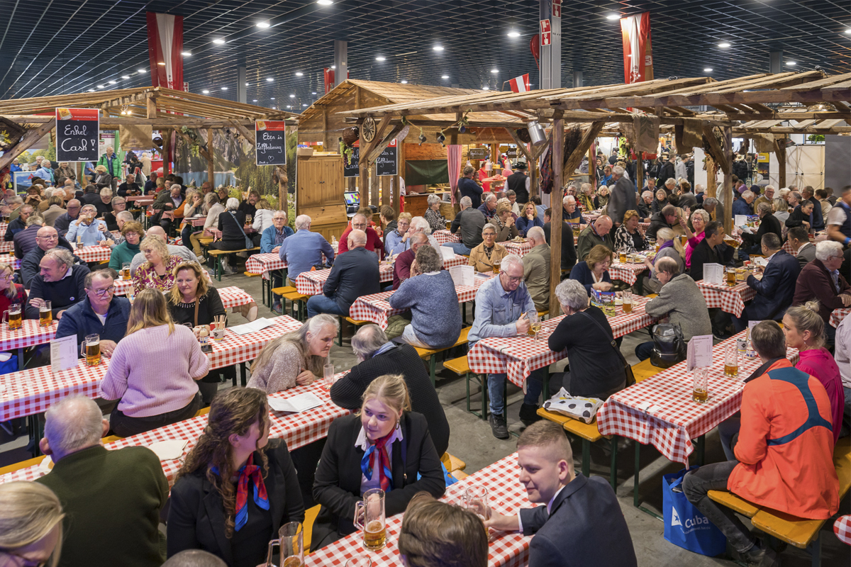 Bezoekers zitten aan bierbanken in de Bierstube