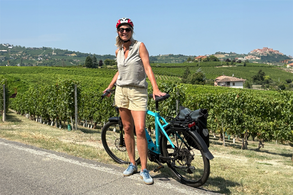 Vrouw met fiets voor wijngaarden