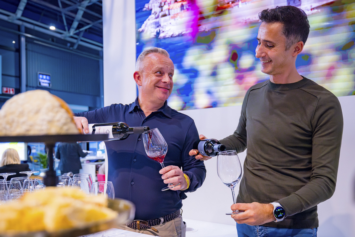 Standhouders schenken glas rode wijn in