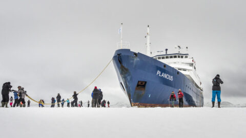 Schip op antarica met mensen op ijs