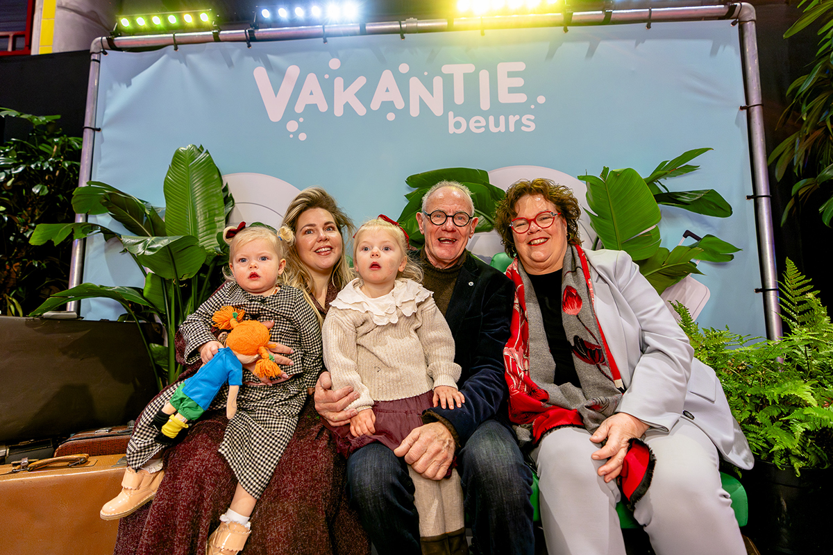 Familie met kinderen voor doek Vakantiebeurs