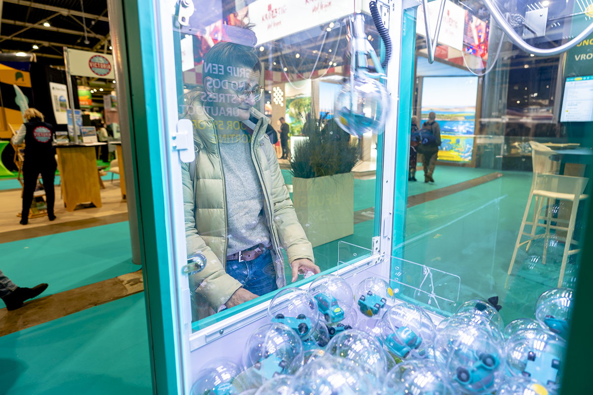 vrouw speelt met grijpmachine op Vakantiebeurs